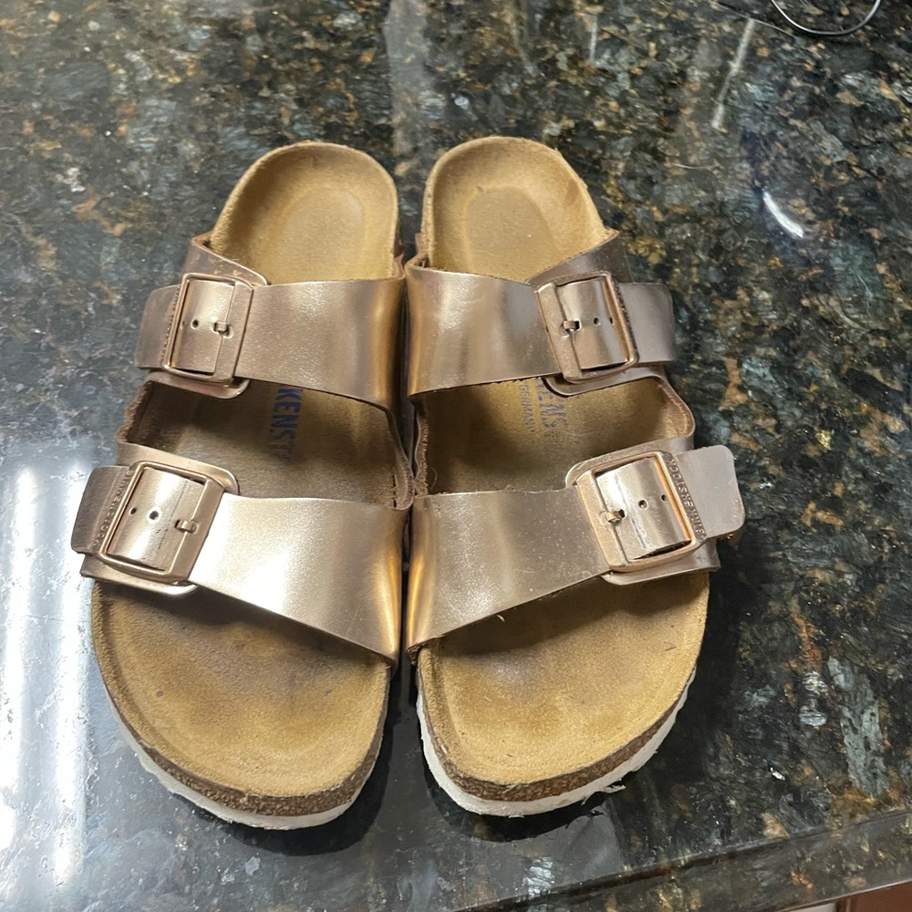 gently worn rose gold Birkenstock Arizona sandal with white sole